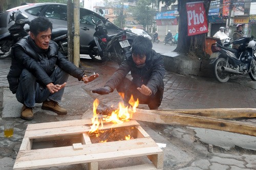 Nhiều người đốt lửa sưởi ấm trên phố.